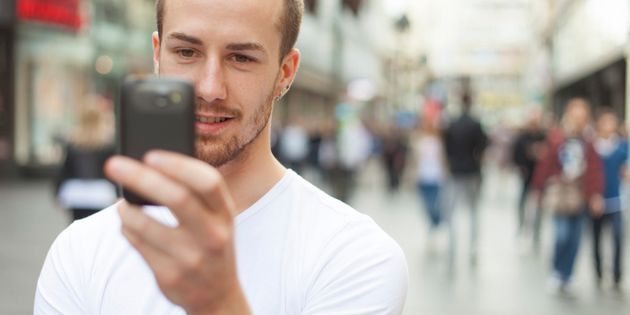 Young Man with cell phone walking